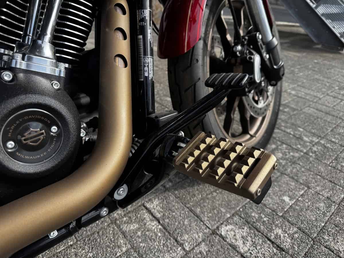 Harley-Davidson Motorrad mit goldener Fußraste und schwarzem Rahmen.