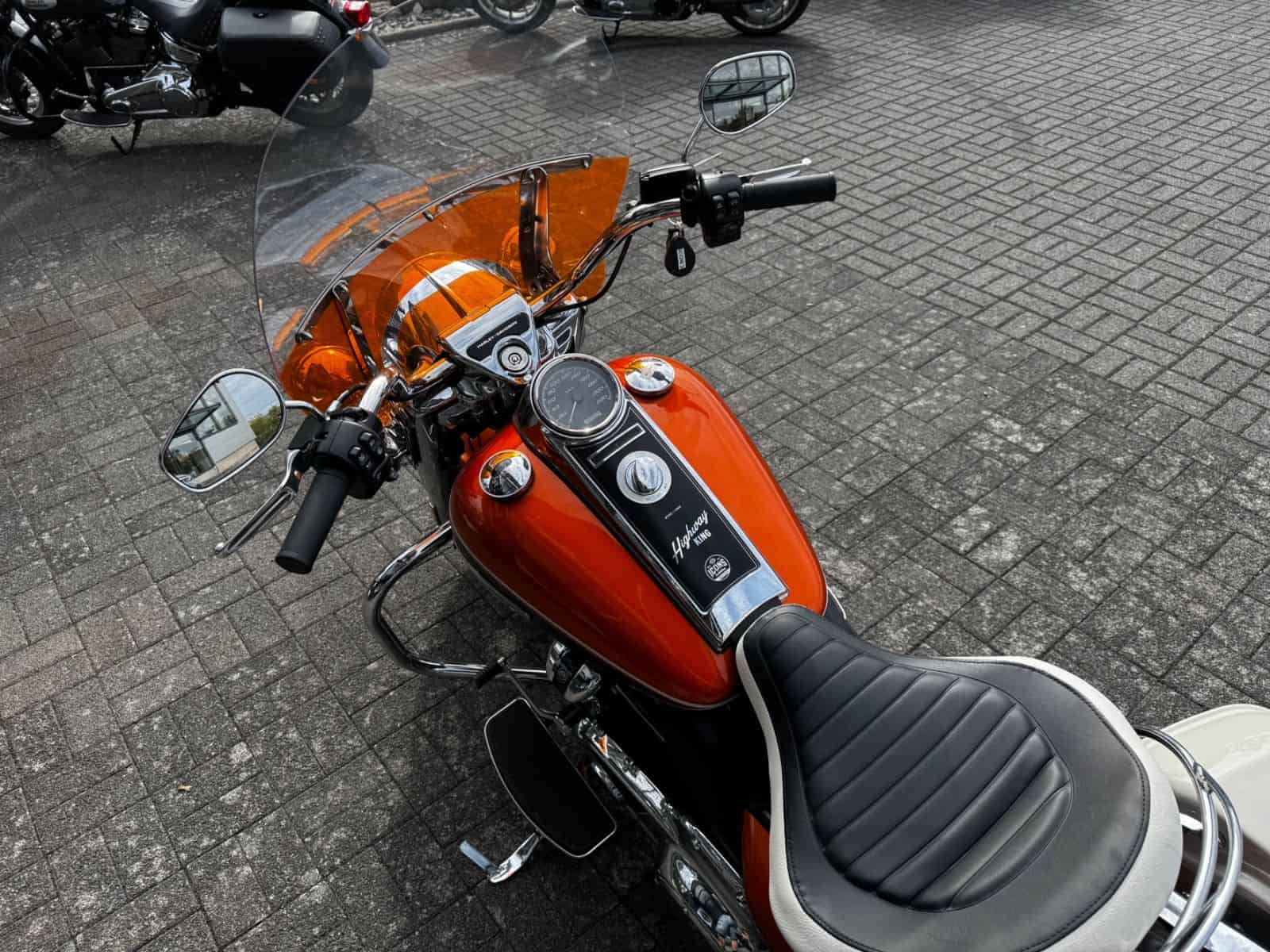 Harley-Davidson Motorrad mit orangefarbenem Tank und Windschutzscheibe.