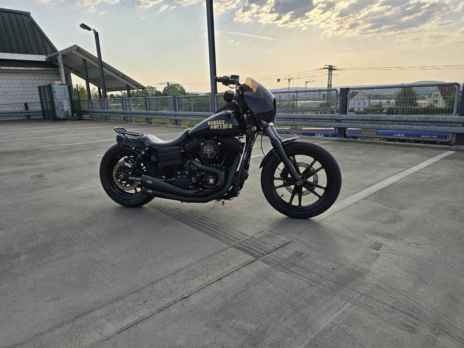 Harley-Davidson Motorrad auf Dachparkplatz bei Sonnenuntergang.