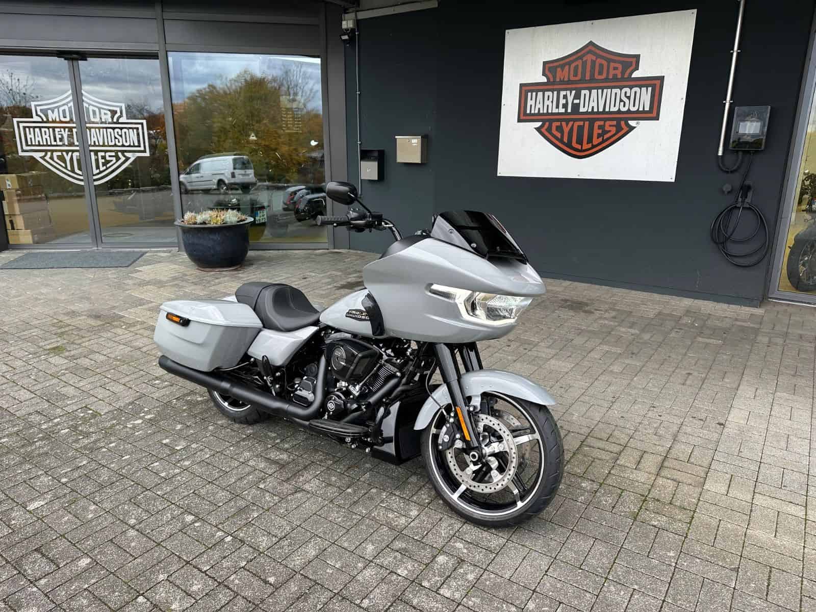 Harley-Davidson Tour-Paket auf schwarzem Harley-Davidson Motorrad vor Händler.