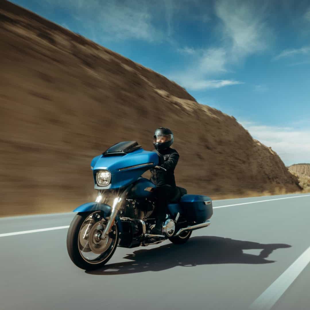 Harley-Davidson Tourenmotorrad in Blau auf offenen Strassen in Wüstenlandschaft.